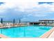 Sparkling blue pool with ample seating, umbrellas, and scenic views of the bridge and surrounding landscape at 6085 Bahia Del Mar Blvd # 106, St Petersburg, FL 33715