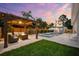 Stunning backyard featuring a pool, spa, and a cozy covered lounge area with comfortable seating and fire pit at 6121 33Rd N Ave, St Petersburg, FL 33710