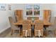 Dining room with rustic table, wood-look flooring, plantation shutters, and display cabinets at 6121 33Rd N Ave, St Petersburg, FL 33710