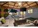 Inviting covered outdoor lounge with comfortable seating, a fire pit, ceiling fan, and TV overlooking the pool at 6121 33Rd N Ave, St Petersburg, FL 33710