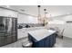 Well-lit kitchen with stainless steel appliances, white cabinetry, and a center island at 6121 Fjord Way, New Port Richey, FL 34652