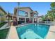 Backyard view featuring a swimming pool, a patio with swing, and exterior stairs to the second floor at 6121 Fjord Way, New Port Richey, FL 34652