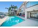 Backyard view featuring a private swimming pool, covered patio, and lush tropical landscaping at 6121 Fjord Way, New Port Richey, FL 34652