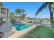 Backyard featuring a swimming pool, waterfront views, lush landscaping, and a well-maintained lawn at 6121 Fjord Way, New Port Richey, FL 34652