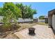 Backyard with a tiled patio and fire pit, shaded by mature trees at 6812 Fountain Ave, Tampa, FL 33634