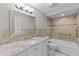 Bright bathroom featuring a granite vanity, shower-tub combo, and tile walls at 6812 Fountain Ave, Tampa, FL 33634