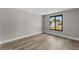 Bedroom featuring gray walls and hard wood floors, plus a window to the outside at 6812 Fountain Ave, Tampa, FL 33634