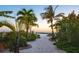 Stunning beach access with sandy paths, mature trees, and lush landscaping at 7150 Sunset Way # 405, St Pete Beach, FL 33706