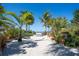 Beautiful sand pathway leading to the beach, surrounded by lush tropical landscaping at 7150 Sunset Way # 405, St Pete Beach, FL 33706