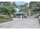 Front gate entrance to the property with lush landscaping and mature trees at 7150 Sunset Way # 405, St Pete Beach, FL 33706