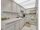 Bright kitchen with white appliances, ample counter space and tiled flooring at 7150 Sunset Way # 405, St Pete Beach, FL 33706