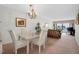 Dining and living area with chandelier lighting, rattan furniture, and balcony access at 7150 Sunset Way # 405, St Pete Beach, FL 33706