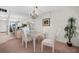 Dining and living area with chandelier lighting, rattan furniture, and balcony access at 7150 Sunset Way # 405, St Pete Beach, FL 33706