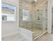 A tile shower with a glass enclosure and large shower head with an external window at 7232 Sutton Ln, Sarasota, FL 34240