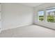 Sunlit bedroom with plush carpet boasts a serene view of the pond at 7232 Sutton Ln, Sarasota, FL 34240