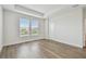 Bright bedroom with wood floors, two windows with blinds, and white trim at 7232 Sutton Ln, Sarasota, FL 34240
