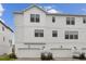 Charming three-story townhome featuring a white exterior and two-car garages at 7232 Sutton Ln, Sarasota, FL 34240