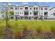 Beautiful three-story townhomes with black metal railings and a well-manicured lawn at 7232 Sutton Ln, Sarasota, FL 34240