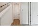 Hallway features hardwood floors and crisp white walls with doors and a staircase at 7232 Sutton Ln, Sarasota, FL 34240