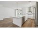 Spacious kitchen with stainless steel appliances, quartz countertops, and a modern island with a wine fridge at 7232 Sutton Ln, Sarasota, FL 34240