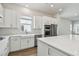 Bright kitchen featuring white cabinets, a farmhouse sink, stainless steel appliances, and quartz countertops at 7232 Sutton Ln, Sarasota, FL 34240