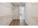 Spacious walk-in closet leads to bathroom, complete with wire shelving and wood-look flooring at 7232 Sutton Ln, Sarasota, FL 34240