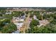 An aerial view looking over the home and neighborhood nestled among mature trees with a view down the tree-lined street at 785 52Nd N Ave, St Petersburg, FL 33703