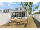 Backyard view of the home with a screened patio, surrounded by a white fence and green lawn at 785 52Nd N Ave, St Petersburg, FL 33703