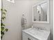 Cozy half-bath with white vanity, marble countertop, and decorative mirror at 785 52Nd N Ave, St Petersburg, FL 33703