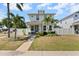 Charming two-story home with manicured lawn and walkway leading to the front door surrounded by palms and white fencing at 785 52Nd N Ave, St Petersburg, FL 33703