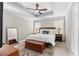 Relaxing main bedroom featuring tray ceiling, ceiling fan, ensuite bath and wood-look flooring at 785 52Nd N Ave, St Petersburg, FL 33703