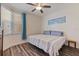 Bright bedroom with a queen size bed, fan, wood floors and wall art at 7922 Sailboat Key S Blvd # 105, South Pasadena, FL 33707