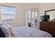 Bedroom with a ceiling fan, a large window with views of the water, and balcony access via shutters at 7922 Sailboat Key S Blvd # 105, South Pasadena, FL 33707