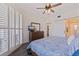 Spacious bedroom featuring a ceiling fan, shuttered glass doors, a full dresser, and bathroom access at 7922 Sailboat Key S Blvd # 105, South Pasadena, FL 33707