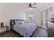 Calming bedroom with ceiling fan, a large window, and balcony access through shuttered glass doors at 7922 Sailboat Key S Blvd # 105, South Pasadena, FL 33707