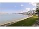 Scenic waterfront view showcasing lush green space bordering the water, complete with a sidewalk and bench at 7922 Sailboat Key S Blvd # 105, South Pasadena, FL 33707
