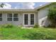 Exterior view of double glass doors and windows overlooking lush landscaped backyard at 805 Bannockburn Ave, Temple Terrace, FL 33617