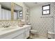 Bathroom featuring golden wallpaper, a bright sink, and decorative accents at 805 Bannockburn Ave, Temple Terrace, FL 33617
