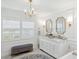 Luxurious bathroom featuring double vanity, gold fixtures, marble counters and floors, chandelier and bench at 805 Bannockburn Ave, Temple Terrace, FL 33617