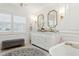 Luxurious bathroom featuring double vanity, gold fixtures, marble counters and floors and shuttered window at 805 Bannockburn Ave, Temple Terrace, FL 33617