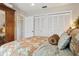 Bedroom features patterned bedding and pillow. There are built in closets and a wooden wardrobe at 805 Bannockburn Ave, Temple Terrace, FL 33617