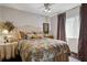Comfortable bedroom with a patterned comforter, side tables, and a window with curtains at 805 Bannockburn Ave, Temple Terrace, FL 33617