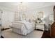 Bright, stylish bedroom with a chandelier, neutral color palette, and decorative mirrors and wall art at 805 Bannockburn Ave, Temple Terrace, FL 33617