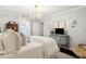 Well-lit bedroom featuring elegant decor, a TV on the dresser, and a partial view of an attached bathroom at 805 Bannockburn Ave, Temple Terrace, FL 33617