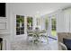 Charming dining area featuring a light green table and chairs with floral cushions, set on elegant marble flooring at 805 Bannockburn Ave, Temple Terrace, FL 33617