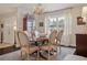 Elegant dining room showcasing a wooden table, upholstered chairs, chandelier, and bright natural light at 805 Bannockburn Ave, Temple Terrace, FL 33617