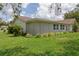 The back exterior of the home showing a green lawn and clean building lines at 805 Bannockburn Ave, Temple Terrace, FL 33617