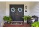 Inviting double front doors adorned with wreaths, complemented by a brick porch, bench and lush ferns at 805 Bannockburn Ave, Temple Terrace, FL 33617