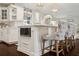 Bright kitchen island with white cabinets, stainless steel microwave, marble countertop and barstool seating at 805 Bannockburn Ave, Temple Terrace, FL 33617