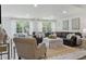 Spacious living room boasts a plush leather sofa, elegant decor, and light-filled windows with sheer curtains at 805 Bannockburn Ave, Temple Terrace, FL 33617